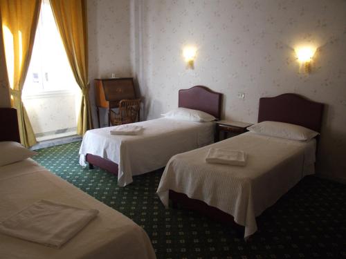 a hotel room with two beds and a window at Hotel Texas in Rome