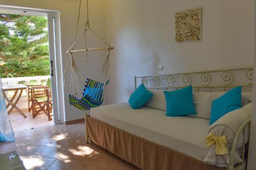 a bedroom with a bed with blue pillows and a swing at Andriana in Agios Georgios
