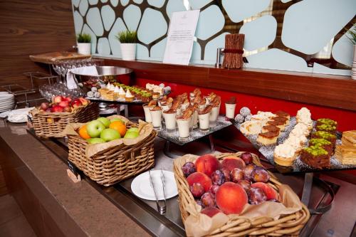 a table topped with lots of different types of food at Imeretinskiy Hotel in Adler