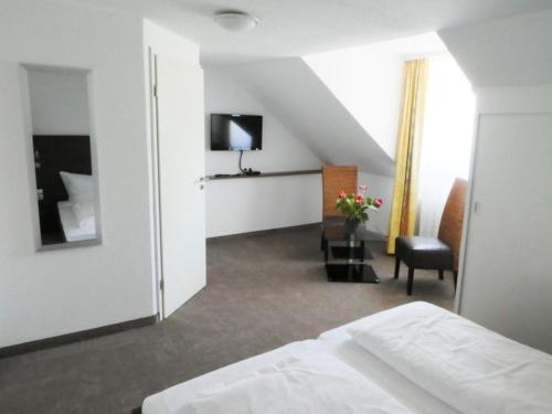 a hotel room with a bed and a chair and a television at Gasthaus zur Alten Post in Hemmenhofen