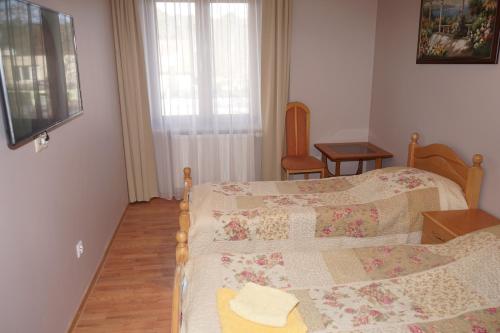 a bedroom with a bed and a table and a window at Willa Joker in Krynica Morska