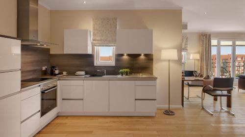 a kitchen with white cabinets and a dining room at Hotel Villa Toskana in Leimen