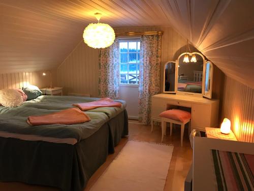 a bedroom with a bed and a desk and a mirror at Vimmerby Lilla utsikten in Tuna