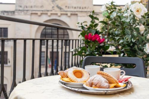 a table with a plate of pastries and cups of coffee at B&B Accademia in Verona