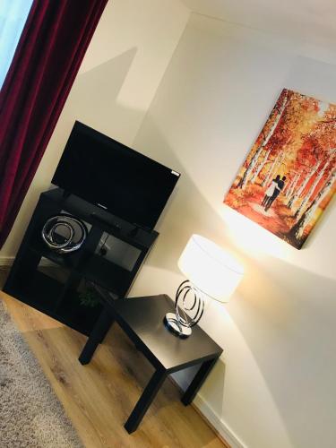 a living room with a tv and a table with a lamp at Arma Short Stays Conifer Drive in Bicester
