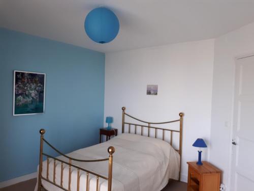 een slaapkamer met een bed en een blauwe muur bij Idéal Panorama du Tréport in Le Tréport