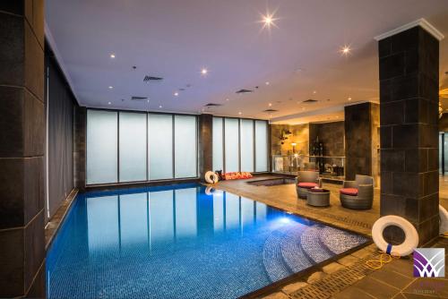 a swimming pool in a building with a house at Normas Hotel in Al Khobar