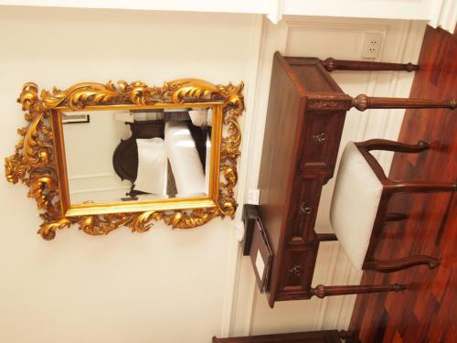 a mirror hanging on a wall next to a staircase at Dhavara Boutique Hotel in Vientiane