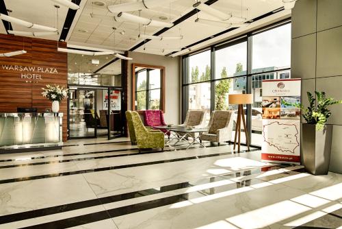 a lobby with chairs and a table in a building at Warsaw Plaza Hotel in Warsaw