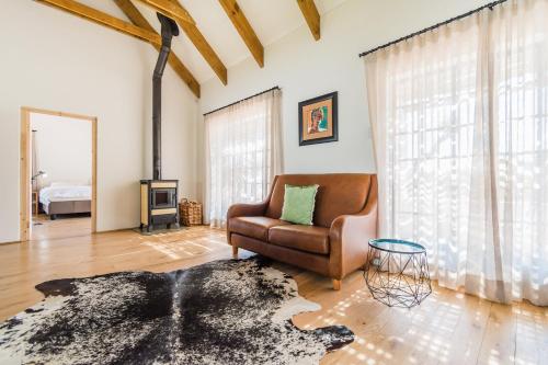 a living room with a leather chair and a fireplace at Druk My Niet Wine Estate in Paarl
