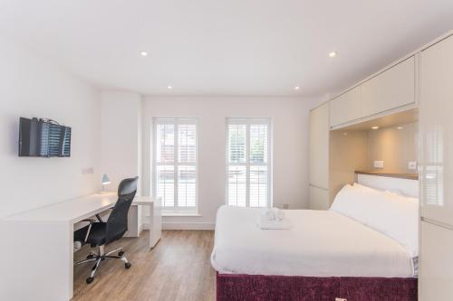 ein Hotelzimmer mit einem Bett und einem Schreibtisch in der Unterkunft Town or Country - Canute Studio in Southampton