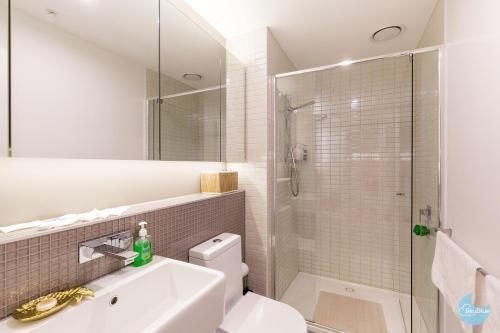 a bathroom with a toilet and a sink and a shower at The Escape in Southern Cross Station in Melbourne