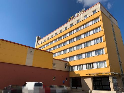 a hotel building with a car parked in front of it at Hotel Patriot in Vranov nad Topľou