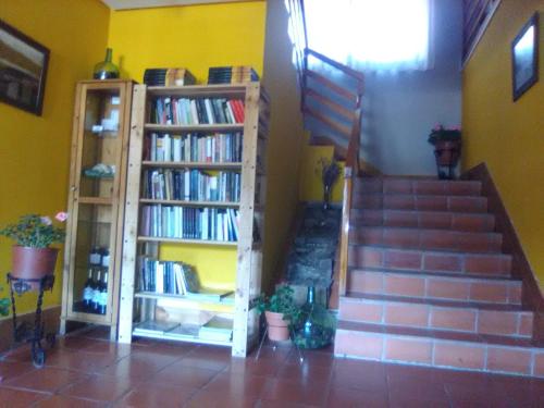 a room with a staircase and book shelves with books at Hotel Villaneila in Neila