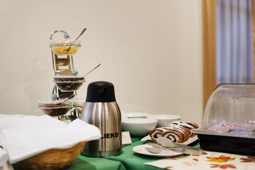 a table with a green table cloth with a thermos at Hotel Patriot in Vranov nad Topľou