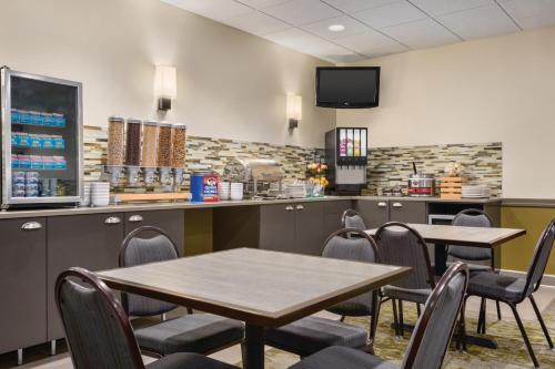 a restaurant with two tables and chairs and a counter at Country Inn & Suites by Radisson, Fergus Falls, MN in Fergus Falls