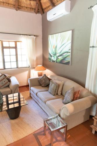a living room with a couch and a table at Blyde River Canyon Lodge in Hoedspruit