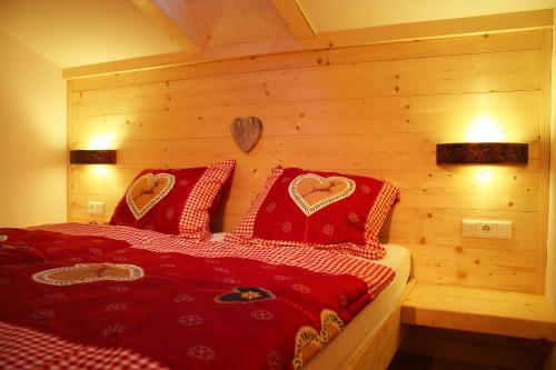 a bedroom with a bed with red pillows with hearts at Apartments Landhaus Sonnheim in Lofer