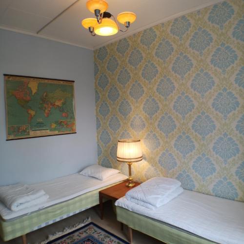 a room with two beds and a lamp on a table at Varbergs Vandrarhem in Varberg