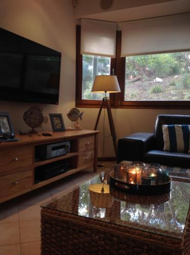a living room with a couch and a tv at Strandmarken in Island Beach