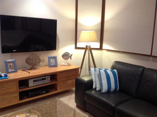 a living room with a couch and a flat screen tv at Strandmarken in Island Beach