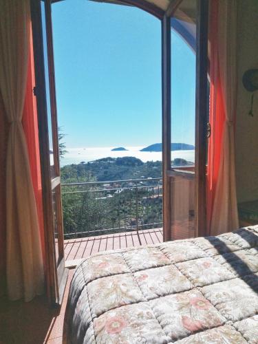 a bedroom with a large glass door to a balcony at Ai Canarbin - colline di Lerici in Lerici