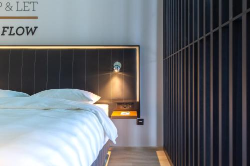 a bedroom with a large white bed with a black headboard at Park Inn by Radisson Poznan in Poznań