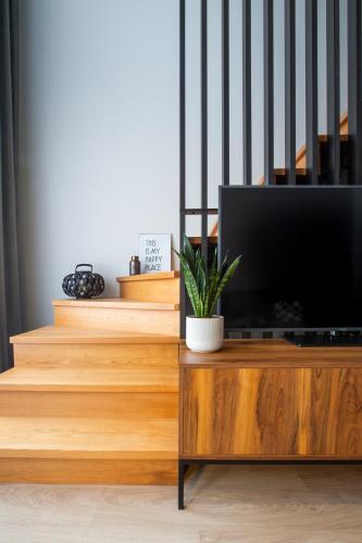 a television on a wooden entertainment center with stairs at Park Inn by Radisson Poznan in Poznań