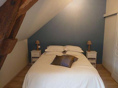 - une chambre avec un lit doté de draps et d'oreillers blancs dans l'établissement Jolie Maison de Campagne en pierre de tuffeau, à Longué