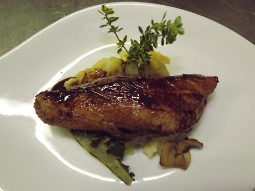 a white plate with a piece of meat and vegetables at Logis Hôtels - Hostellerie des Lauriers - Hôtel et Restaurant in Alban