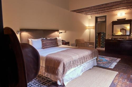 a bedroom with a large bed and a mirror at BE Jardin Escondido By Coppola in Buenos Aires