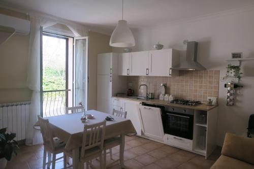 a kitchen with white cabinets and a table and a dining room at La Palombara in Ponzano Romano
