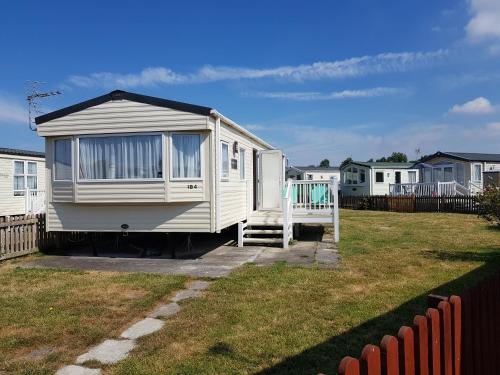 a mobile home parked in a yard next to a fence at 184 Unity Resort Brean in Brean