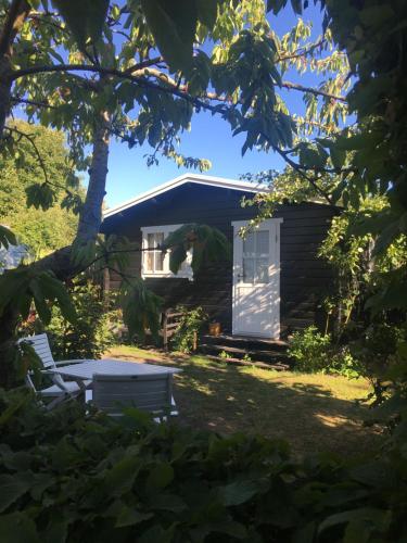 a cabin with a table and chairs in the yard at Bådhuset, Ballen in Ballen