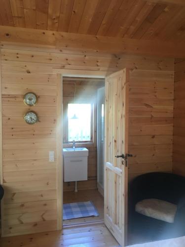- une salle de bains dans une cabane en rondins avec lavabo dans l'établissement Bådhuset, Ballen, à Ballen