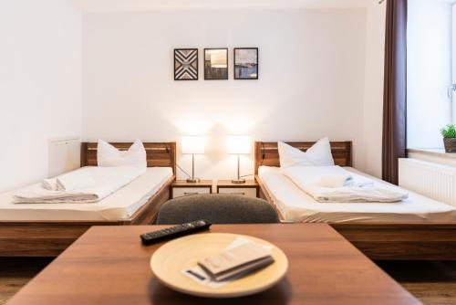ein Hotelzimmer mit 2 Betten und einem Tisch in der Unterkunft greenpartment Boardinghouse Neustadt in Neustadt an der Donau