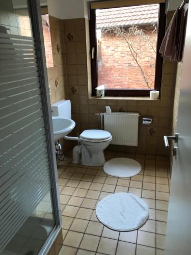 ein Bad mit einem WC, einem Waschbecken und einem Fenster in der Unterkunft OG Mitte 108A 2 Zimmer Apartment in Holzminden