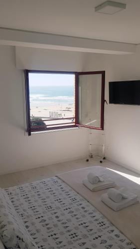 a white bedroom with a large window and a bed at Porto Sea Apartments in Matosinhos