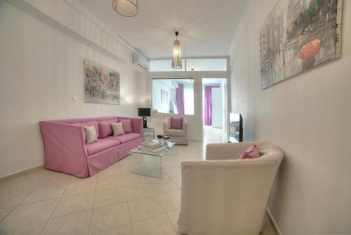 - un salon avec un canapé et des chaises roses dans l'établissement Downtown Glyfada smart apartment, à Athènes