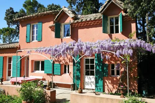 une maison avec des fleurs violettes devant dans l'établissement Campagne Bertani, à Villeneuve-lès-Avignon