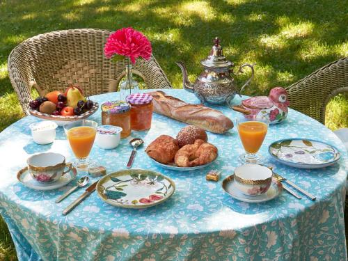une table avec un petit-déjeuner composé de pain et de jus d'orange dans l'établissement Campagne Bertani, à Villeneuve-lès-Avignon