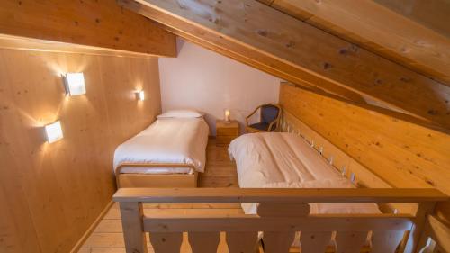 a small room with two beds in a attic at Sport Hotel Alpina in Madesimo