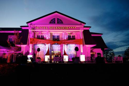 a building lit up in pink with a hotel stafford at Hotel Splendor in Babice Nowe