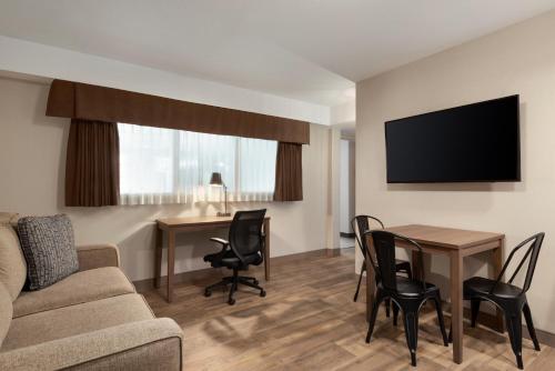 a living room with a couch and a table with chairs at Canalta Airdrie in Airdrie