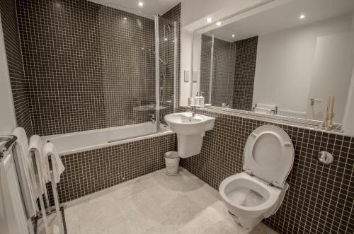 - une salle de bains en noir et blanc pourvue de toilettes et d'un lavabo dans l'établissement Orange Apartments Polmuir Gardens Only 7 minutes to City Centre, à Aberdeen