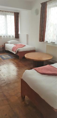 a room with two beds and a table and windows at Coroian House in Cluj-Napoca