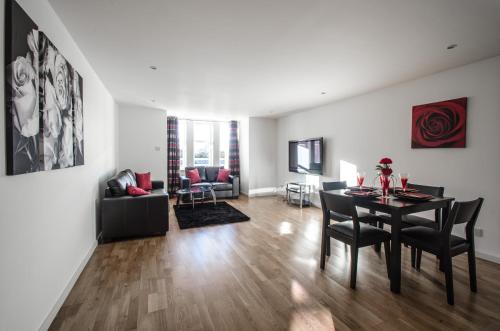 a dining room and living room with a table and chairs at Orange Apartments Polmuir Gardens Only 7 minutes to City Centre in Aberdeen