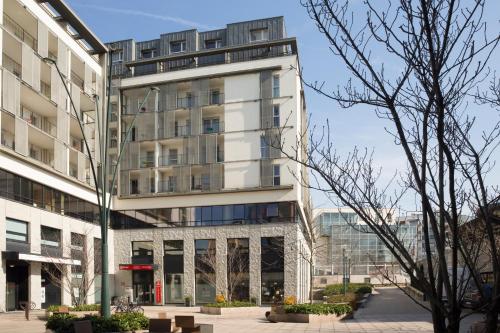 a tall white building with a lot of windows at Aparthotel Adagio Annecy Centre in Annecy