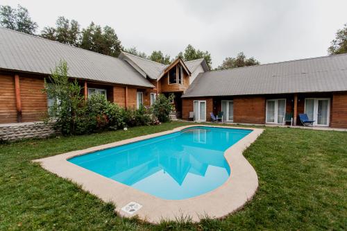a swimming pool in the yard of a house at Cabañas Hosteria de Vilches in Vilches