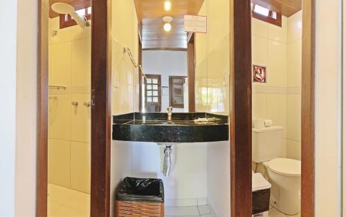 y baño con lavabo y espejo. en Pousada Brasil Caribe, en Morro de São Paulo